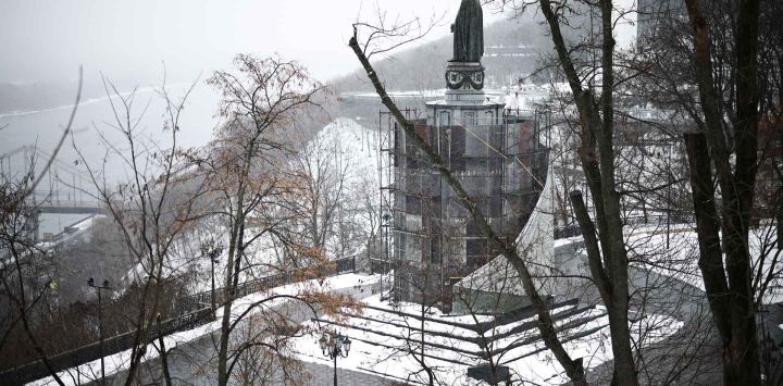 Un peatón camina frente al Monumento a Volodímir el Grande en Kiev. Foto de HENRY NICHOLLS / AFP