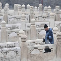 Un trabajador limpia un puente antes de la visita del canciller alemán Friedrich Merz a la Ciudad Prohibida en Pekín. Foto de Pedro PARDO / AFP | Foto:AFP