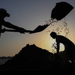 Hombres palanean arena en camiones en el puente María Nieves, en las orillas del río Apure en San Fernando de Apure. Foto de Federico PARRA / AFP | Foto:AFP