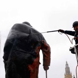 Un trabajador elimina graffiti Ude una estatua del ex primer ministro británico Winston Churchill en Parliament Square. Foto de Brook Mitchell / AFP | Foto:AFP