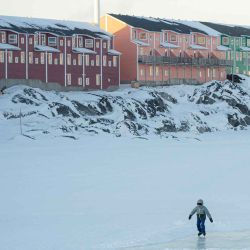 Un niño patina sobre hielo en un lago congelado junto a viviendas recientemente construidas en Nuuk, Groenlandia. Foto de Florent VERGNES / AFP | Foto:AFP
