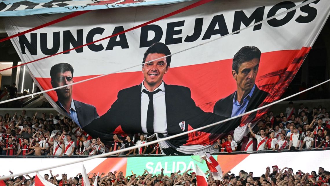 Fans of River Plate display a flag in honour of head coach Marcelo Gallardo during the Argentine Professional Football League 2026 Apertura Tournament match between River Plate and Banfield at the Mas Monumental Stadium in Buenos Aires on February 26,…