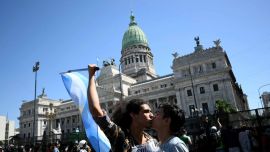 Hombres se besan durante una protesta frente al edificio del Congreso, donde se están tratando las reformas laborales del presidente de Argentina, Javier Milei. Foto de Luis Robayo / AFP