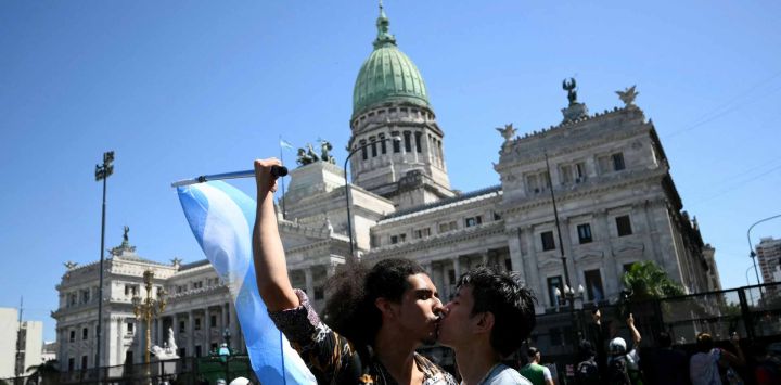 Hombres se besan durante una protesta frente al edificio del Congreso, donde se están tratando las reformas laborales del presidente de Argentina, Javier Milei. Foto de Luis Robayo / AFP