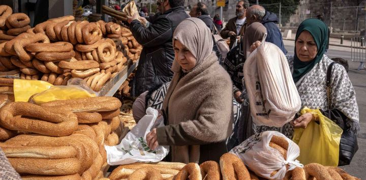 Una mujer compra pan en una panadería en la ciudad vieja de Jerusalén. Foto de JOHN WESSELS / AFP