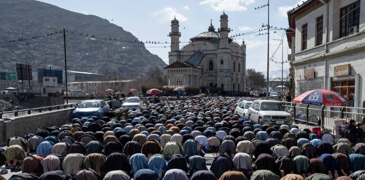 Devotos musulmanes afganos ofrecen las segundas oraciones del viernes durante el sagrado mes de ayuno islámico de Ramadán a lo largo de una carretera en Kabul. Foto de Wakil KOHSAR / AFP 