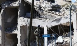 Un soldado custodia un edificio en Tel Aviv alcanzado por un misil israelí.