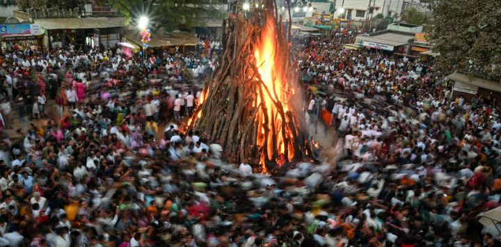 Los devotos realizan rituales alrededor de un fuego sagrado llamado 'Holika Dahan' como parte de Holi, el festival hindú. Foto de Shammi MEHRA / AFP