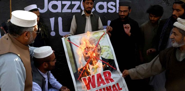 Activistas y simpatizantes del partido Jamaat-e-Islami queman un cartel del presidente de Estados Unidos, Donald Trump, durante una protesta contra Estados Unidos e Israel en Peshawar. Foto de Abdul MAJEED / AFP