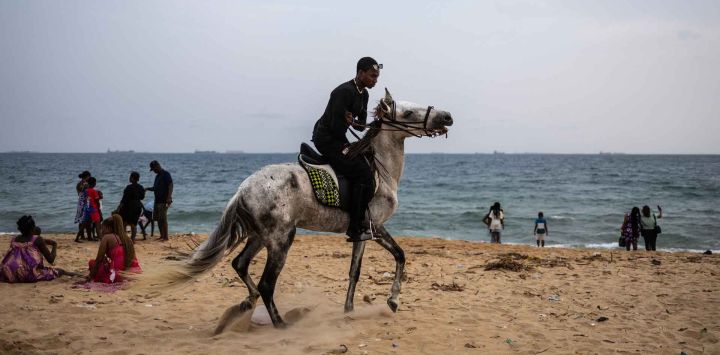 Un hombre monta un caballo en la playa en Lomé. Foto de OLYMPIA DE MAISMONT / AFP