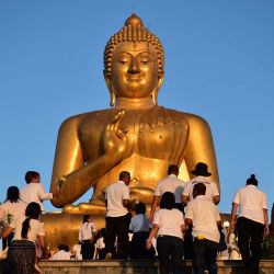 Devotos budistas caminan hacia una estatua gigante de Buda durante un evento para conmemorar el Día de Makha Bucha. Foto de Madaree TOHLALA / AFP | Foto:AFP