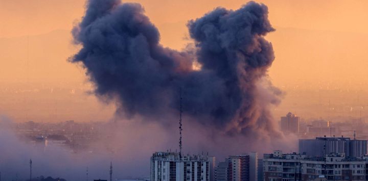 Una columna de humo se eleva después de un ataque en la capital iraní, Teherán. Foto de ATTA KENARE / AFP