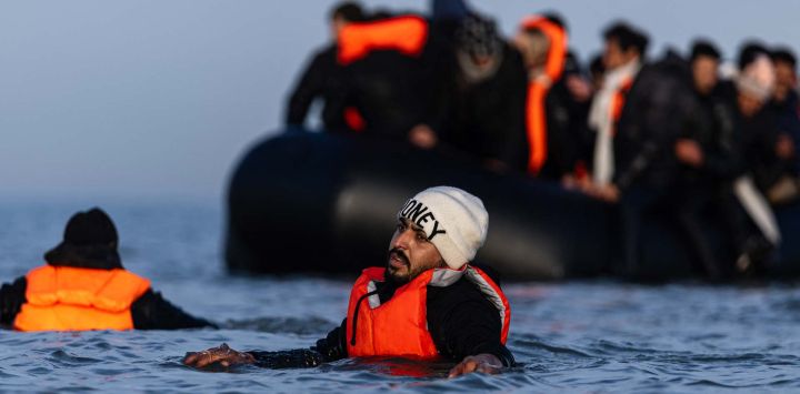 Un migrante intenta abordar un bote de traficantes en un intento de cruzar el Canal de la Mancha desde la playa de Gravelines, en el norte de Francia. Foto de Sameer Al-DOUMY / AFP