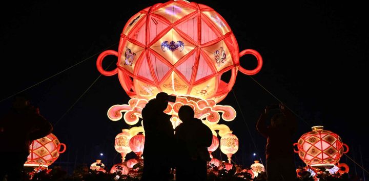 Los visitantes toman fotos en un parque durante el Festival de los Faroles en Pekín. Foto de Pedro PARDO / AFP
