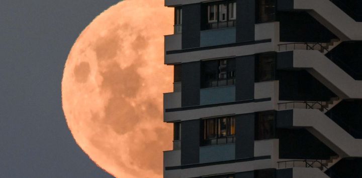 La luna se eleva en su fase gibosa creciente detrás de un edificio en Buenos Aires. Foto de Luis ROBAYO / AFP