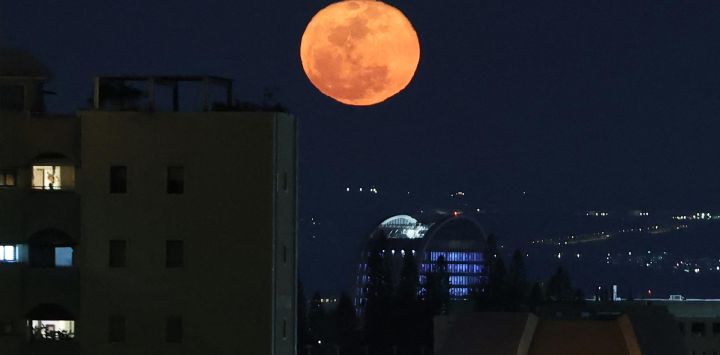 La luna gibosa menguante se eleva sobre Tel Aviv. Foto de Jack GUEZ / AFP