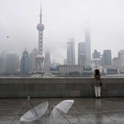 Una mujer toma una foto del distrito financiero de Lujiazui al otro lado del río Huangpu desde el paseo del Bund en Shanghái. Foto de Jade GAO / AFP | Foto:AFP
