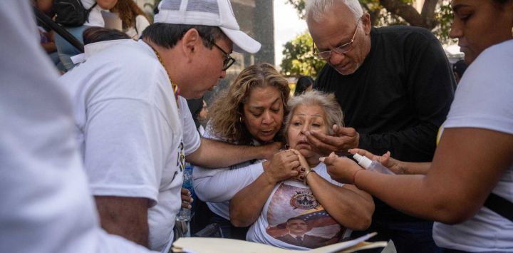 Nanci Penaloza se desmaya durante una manifestación de familiares de presos políticos frente al edificio del parlamento nacional en Caracas. Foto de Maryorin Mendez / AFP