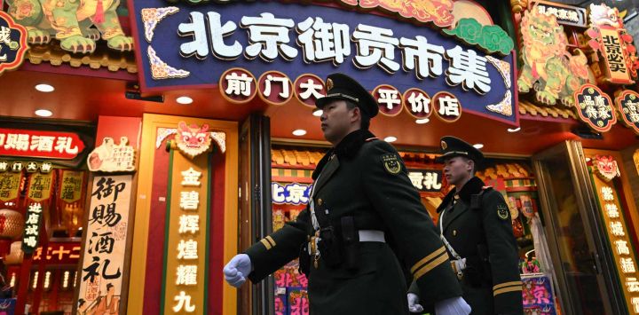 Policías paramilitares chinos patrullan en una calle frente al Gran Salón del Pueblo, sede de la sesión inaugural del Congreso Nacional del Pueblo (CNP), en Pekín. Foto de Pedro PARDO / AFP