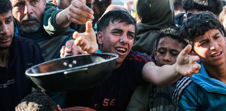 Palestinos desplazados se agolpan por comida en un banco de alimentos en Khan Yunis, en el sur de la Franja de Gaza. Foto de Bashar Taleb / AFP