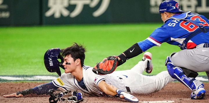 El taiwanés Shao-Hung Chiang (der.) batea al surcoreano Kim Ju-won en el plato durante el partido del Grupo C del Clásico Mundial de Béisbol (CMB) entre Taiwán y Corea del Sur en el Tokyo Dome, Tokio.