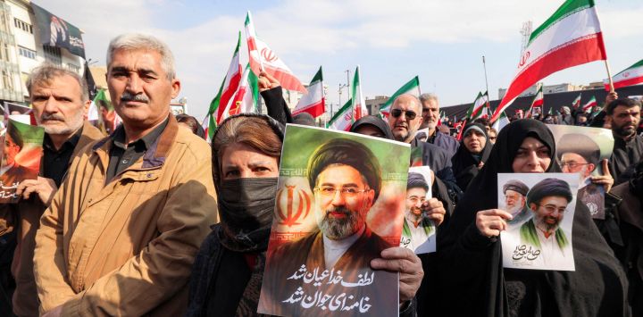 Una mujer posa con una foto del nuevo líder supremo de Irán, el ayatolá Mojtaba Jamenei, durante una manifestación en su apoyo en la plaza Enghelab, en el centro de Teherán. Irán celebró el nombramiento del ayatolá Mojtaba Jamenei como líder supremo en reemplazo de su padre con una nueva andanada de misiles contra Israel y los países del Golfo el lunes, mientras la guerra en Oriente Medio disparaba los precios del petróleo.