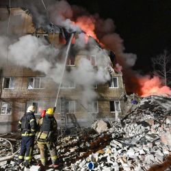 Los bomberos extinguen un incendio y retiran los escombros de un edificio residencial de cinco plantas en Járkov, tras ser parcialmente destruido por un ataque ruso durante la invasión rusa de Ucrania. | Foto:SERGEY BOBOK / AFP