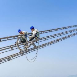 Vista aérea tomada con un dron de trabajadores de mantenimiento revisando la Línea Jintang de ultra alta tensión de ±800 kV junto al río Yangtse, en el distrito de Zongyang de la ciudad de Tongling, en la provincia de Anhui, en el este de China. | Foto:Xinhua/Zheng Xianlie