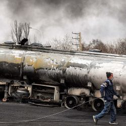 Un miembro de la defensa civil iraní camina con una manguera junto a un camión cisterna de combustible destruido cerca de un incendio en curso tras un ataque aéreo nocturno contra la refinería de petróleo de Shahran, en el noroeste de Teherán. Estados Unidos e Israel lanzaron ataques contra Irán, lo que provocó una rápida represalia por parte de la república islámica, que respondió con ataques con misiles en toda la región. La guerra ha arrastrado a las potencias mundiales, ha trastocado los sectores energético y del transporte a nivel mundial y ha sembrado el caos incluso en zonas habitualmente pacíficas de la inestable región. | Foto:AFP