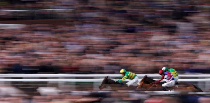 El jockey Richie McLernon monta al caballo de carreras n.° 7 Johnnywho (izq.) para ganar por delante del segundo clasificado Jagwar (der.), montado por Mark Walsh, y del tercer clasificado Quebecois, montado por Harry Cobden, en el Trustmarque Ultima Handicap Chase, el primer día del Festival de Cheltenham en el hipódromo de Cheltenham, en Cheltenham, oeste de Inglaterra.