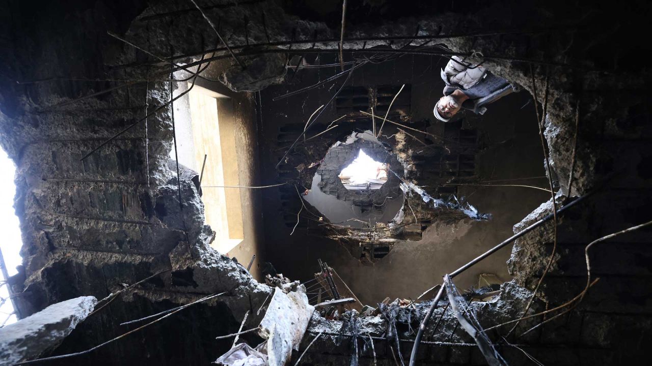  Un hombre palestino observa los daños que, según los residentes, fueron causados por fragmentos de un cohete iraní interceptado que impactó en un edificio palestino de tres plantas en la ciudad cisjordana de Bidya, al oeste de Salfit. El ejército israelí anunció el inicio de una nueva oleada de ataques a gran escala en Irán, que también impactaba infraestructuras de Hezbolá en Beirut, la capital del Líbano. Los nuevos ataques, dirigidos contra lo que el ejército israelí denominó "infraestructuras del régimen terrorista iraní", se produjeron en el duodécimo día de la guerra entre Estados Unidos e Israel contra Teherán. | Foto:JAAFAR ASHTIYEH / AFP