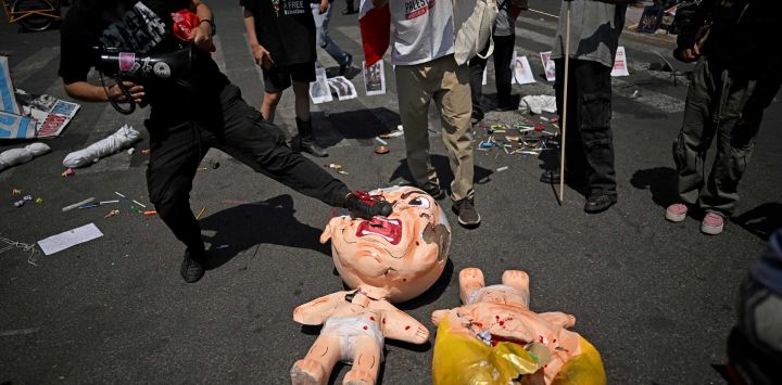 Un manifestante patea una piñata que representa al primer ministro israelí, Benjamin Netanyahu, frente al consulado estadounidense durante una protesta contra el conflicto en Oriente Medio en la Ciudad de México.