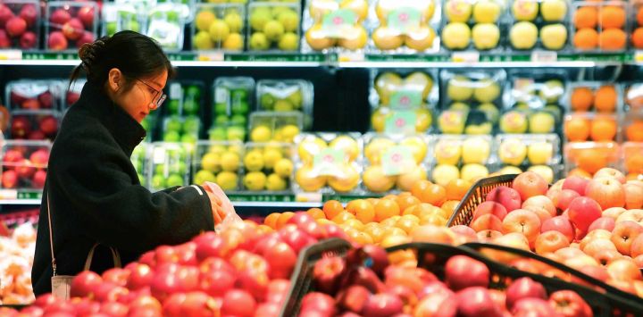 Una cliente selecciona frutas en un supermercado, en Wuxi, en la provincia de Jiangsu, en el este de China. El índice de precios al consumidor (IPC) de China, un indicador principal de la inflación, aumentó un 1,3 por ciento interanual en febrero, impulsado por los efectos de las vacaciones de la Fiesta de la Primavera, según datos oficiales.
