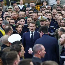 El presidente francés, Emmanuel Macron (centro), canta el himno nacional francés tras dirigirse a la tripulación del portaaviones Charles de Gaulle, desplegada en el mar Mediterráneo tras los ataques con drones iraníes contra Chipre, en el marco de su viaje a Chipre para abordar la seguridad regional. | Foto:Gonzalo Fuentes / POOL / AFP