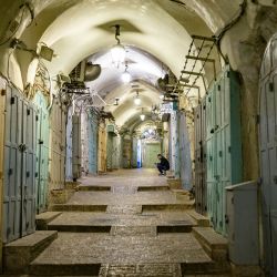 Un hombre se sienta frente a una tienda cerrada en la vacía Ciudad Vieja de Jerusalén. Una semana después del inicio de la ofensiva israelí-estadounidense contra Irán, millones de israelíes se ven interrumpidos día y noche por repetidas sirenas que les advierten que se dirijan a refugios ante la llegada de misiles iraníes. | Foto:ODD ANDERSEN / AFP