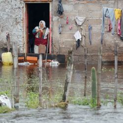 Una mujer observa desde su casa durante una inundación en Agua Azul, provincia de Tucumán, Argentina. | Foto:Walter Monteros / AFP