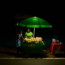 Una mujer vende mangos en un puesto callejero a lo largo de la Cinta Costera en la Ciudad de Panamá. | Foto:MARTIN BERNETTI / AFP