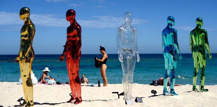 Esta foto muestra a un bañista frente a la instalación "ART (Tiempo Real Artificial)" de Erica Zaino, en la exposición Esculturas junto al Mar en la playa de Cottesloe, Perth, Australia.