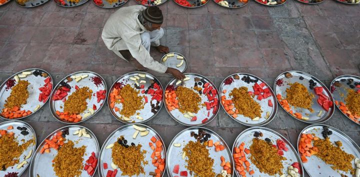 Un devoto musulmán prepara platos de iftar durante el mes sagrado islámico de ayuno del Ramadán en una mezquita de Ahmedabad, India.