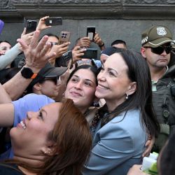 La líder de la oposición venezolana, María Corina Machado, se toma una selfie con miembros de la comunidad venezolana tras recibir las llaves de la ciudad en Santiago, Chile. | Foto:RODRIGO ARANGUA / AFP