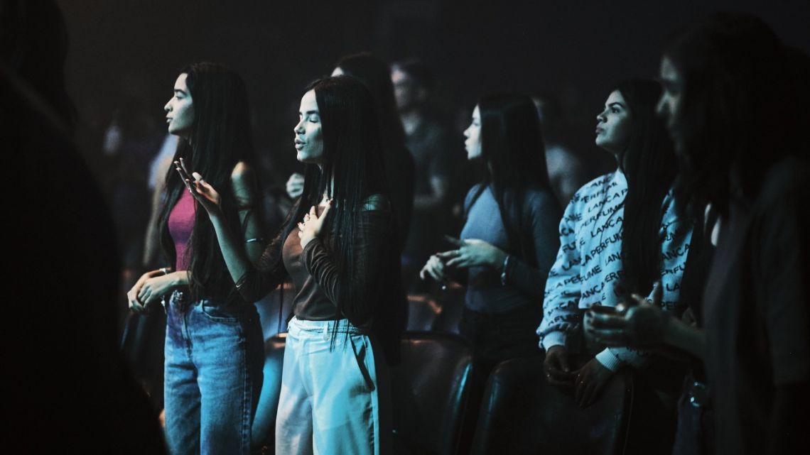 Young Brazilians listen as a pop-rock gospel band plays during a youth service at the Casa Church in Goiânia.