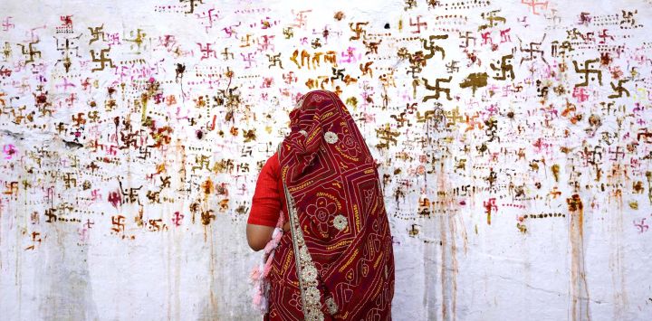 Una mujer realiza rituales para el bienestar de su familia durante el festival hindú Sheetla Saptami en Ajmer, India.