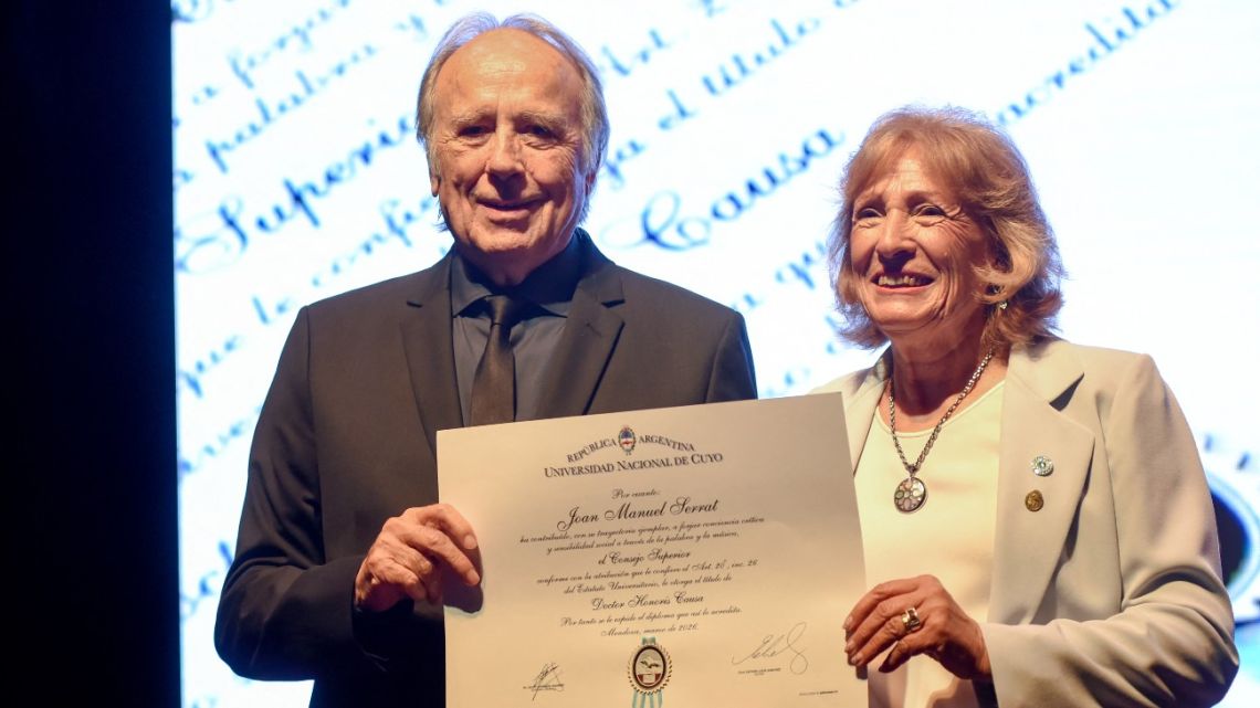 Spanish singer-songwriter Joan Manuel Serrat, accompanied by Esther Sánchez, rector of the National University of Cuyo, receives an honorary doctorate during a ceremony at the Nave UNCuyo complex in Mendoza, Argentina, on March 13, 2026.