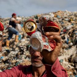 Un recolector de materiales reciclables sostiene latas en un vertedero a cielo abierto en la ciudad de Iranduba, en el estado de Amazonas, al norte de Brasil. El vertedero a cielo abierto de Iranduba representa una crisis ambiental y de salud pública, ya que opera ilegalmente desde hace 40 años, contaminando el suelo y las aguas subterráneas. | Foto:MICHAEL DANTAS / AFP