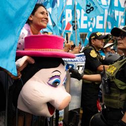 Una simpatizante con una máscara de cerdo hace un gesto mientras espera la llegada del candidato presidencial peruano Rafael López Aliaga, del partido Renovación Popular, a un mitin en el distrito de San Juan de Lurigancho, en las afueras de Lima. Perú celebrará elecciones presidenciales el 12 de abril de 2026. | Foto:ERNESTO BENAVIDES / AFP