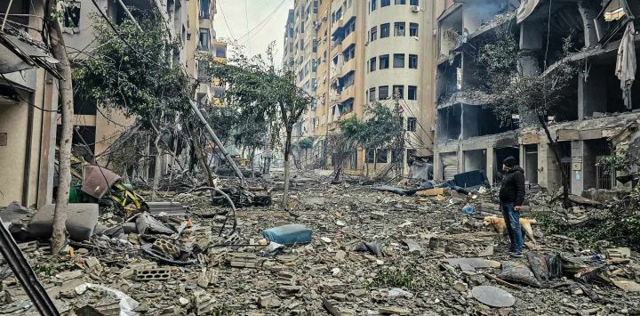 Un hombre y su perro caminan entre los escombros de un edificio en el lugar de un ataque aéreo israelí en Haret Hreik, un suburbio al sur de Beirut. Líbano está trabajando para formar una delegación que negocie con Israel para detener la guerra con Hezbolá, respaldado por Irán, según declaró un funcionario a la AFP, aunque Israel no se ha comprometido con la iniciativa.
