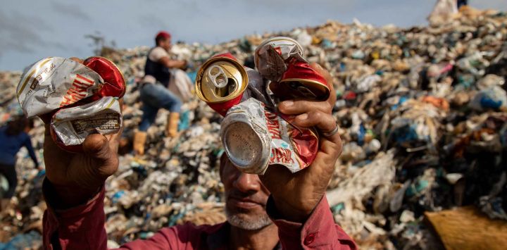 Un recolector de materiales reciclables sostiene latas en un vertedero a cielo abierto en la ciudad de Iranduba, en el estado de Amazonas, al norte de Brasil. El vertedero a cielo abierto de Iranduba representa una crisis ambiental y de salud pública, ya que opera ilegalmente desde hace 40 años, contaminando el suelo y las aguas subterráneas.