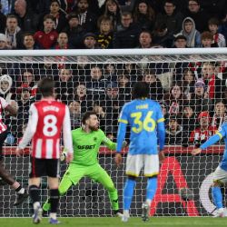 El defensor italiano del Brentford, Michael Kayode (izq.), número 33, anota de cabeza el primer gol durante el partido de la Premier League inglesa entre el Brentford y el Wolverhampton Wanderers en el Gtech Community Stadium de Londres. | Foto:Adrian Dennis / AFP