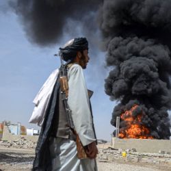 Un miembro del personal de seguridad talibán camina mientras el humo se eleva desde el lugar tras los ataques aéreos pakistaníes nocturnos contra depósitos de petróleo para aerolíneas comerciales, cerca del aeropuerto de Kandahar, en el distrito de Daman, provincia de Kandahar. Las autoridades afganas informaron que los ataques pakistaníes contra Kabul y las provincias fronterizas causaron la muerte de cuatro personas en la capital y dos en el este, en los últimos enfrentamientos mortales del prolongado conflicto. | Foto:AFP