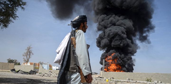 Un miembro del personal de seguridad talibán camina mientras el humo se eleva desde el lugar tras los ataques aéreos pakistaníes nocturnos contra depósitos de petróleo para aerolíneas comerciales, cerca del aeropuerto de Kandahar, en el distrito de Daman, provincia de Kandahar. Las autoridades afganas informaron que los ataques pakistaníes contra Kabul y las provincias fronterizas causaron la muerte de cuatro personas en la capital y dos en el este, en los últimos enfrentamientos mortales del prolongado conflicto.